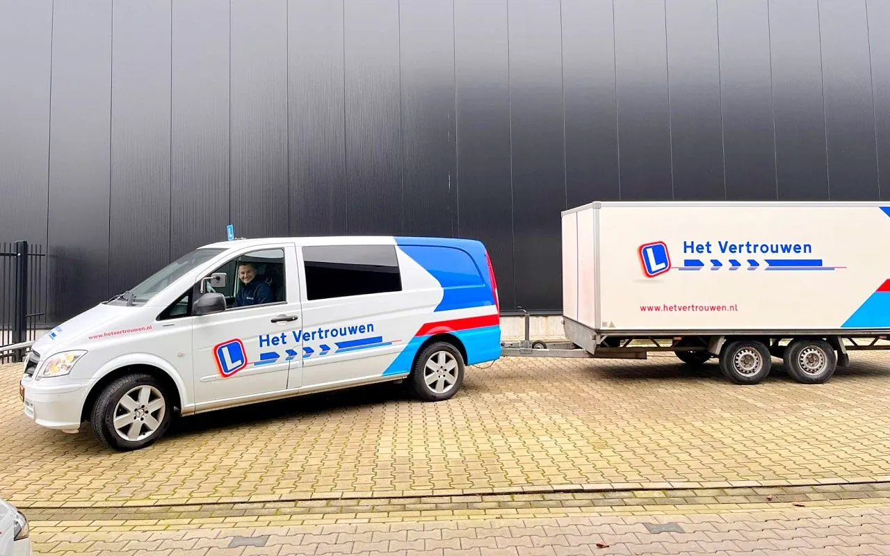Bestelbus met aanhangwagen van Het Vertrouwen Opleidingen