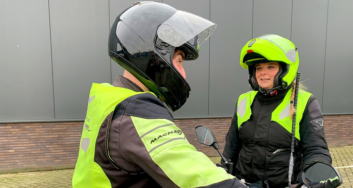 Motorinstructeur geeft uitleg aan een leerling op de lesmotor